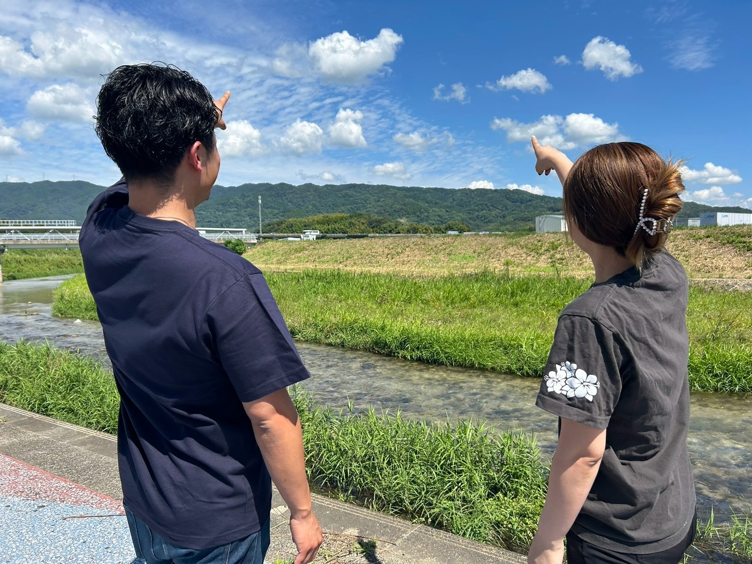 青空を指すコムソワのスタッフ