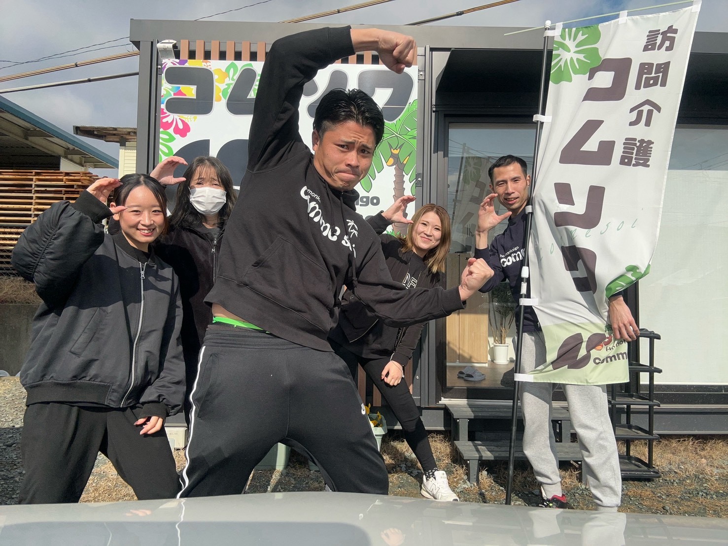 事業所前で笑顔のコムソワのスタッフ集合写真